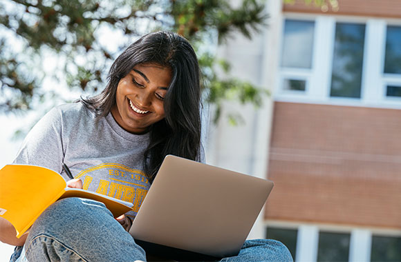 female student writing notes in notebook